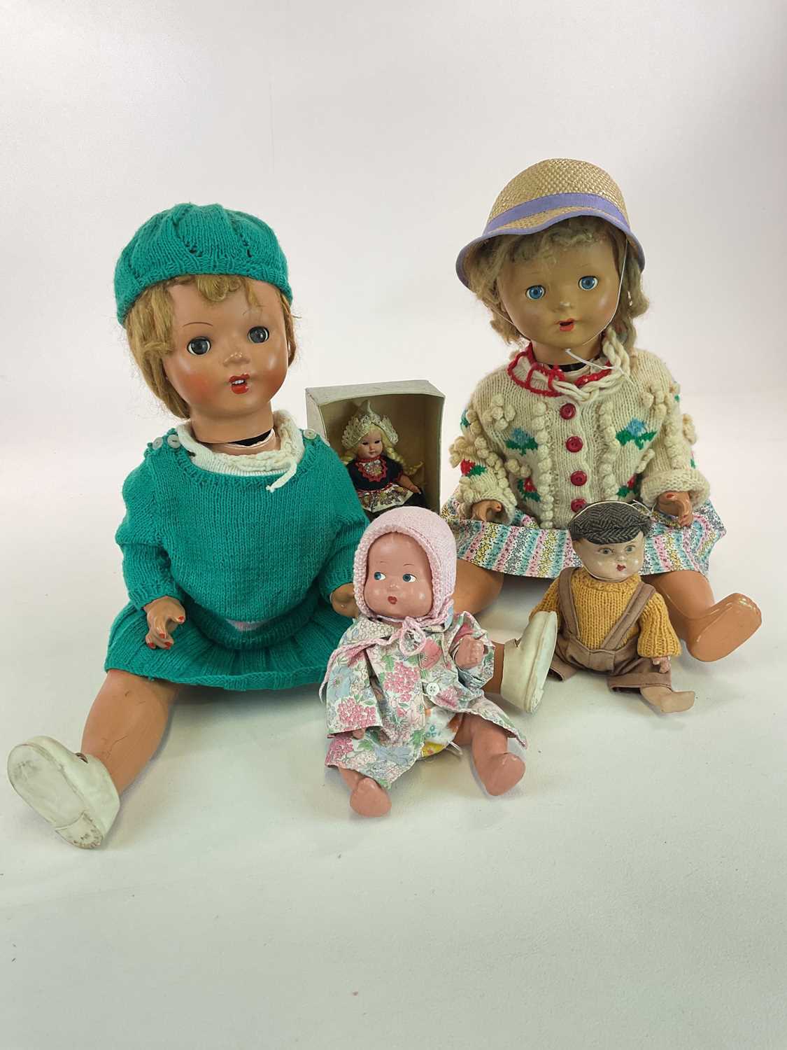 A group of five dolls including a 22" 1940s composition doll with sleeping eyes and pierced ears (