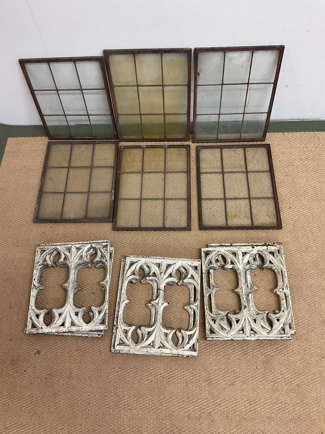 Six copper framed windows, 38 x 28cm, and six cast iron decorative panels, 30 x 26cm.