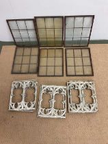 Six copper framed windows, 38 x 28cm, and six cast iron decorative panels, 30 x 26cm.