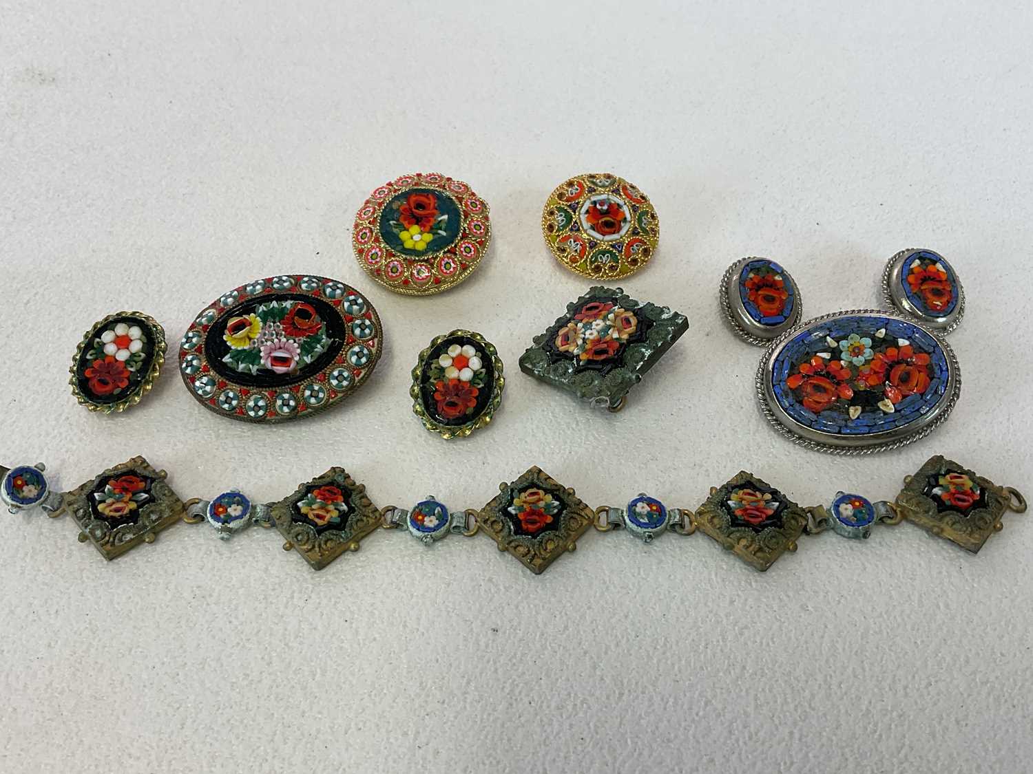 A group of micromosiac jewellery, including bracelet, several brooches, and two pairs of clip on