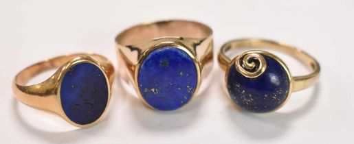 Two 9ct yellow gold and a yellow metal ring, each set with lapis lazuli, sizes Q, S and T,