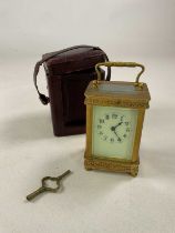 A brass carriage clock with pierced decoration to the case, the enamelled dial set with Arabic