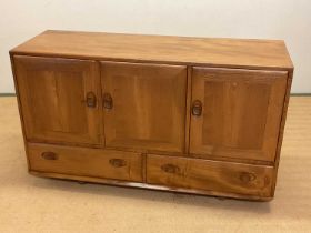 ERCOL; a sideboard on castors, with two cupboards over two drawers, a single door cupboard and
