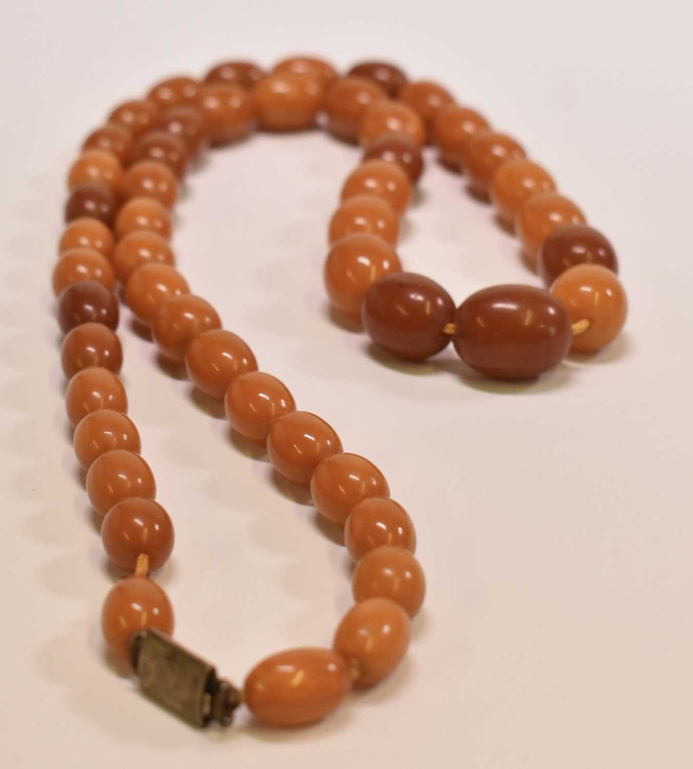 A vintage butterscotch/egg yolk graduated amber bead necklace, length 81cm, the largest bead