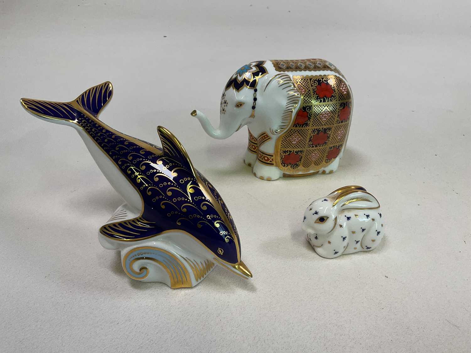 ROYAL CROWN DERBY; animal paperweights comprising an elephant (9cm), a dolphin and a rabbit, boxed