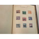 A stamp album sparsely filled including British Isles, Caribbean, Canada, Falkland Islands, etc.