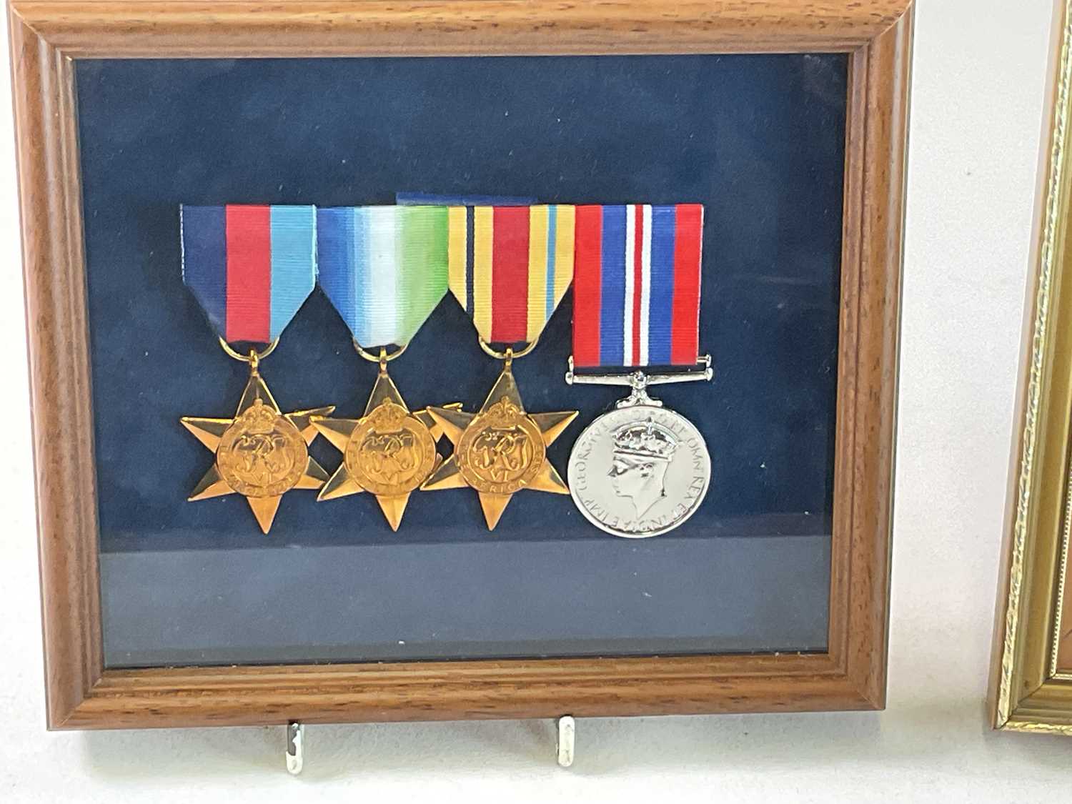 A set of four re-issued WWII medals, framed and glazed, and a single restruck medal in a separate - Image 2 of 3