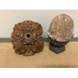 A carved pine acorn newel post, height 28cm, and a carved wooden boss, 25cm (2).