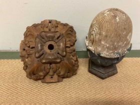 A carved pine acorn newel post, height 28cm, and a carved wooden boss, 25cm (2).