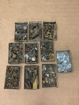 A quantity of brass furniture fittings contained in ten small trays, to include clock winders,
