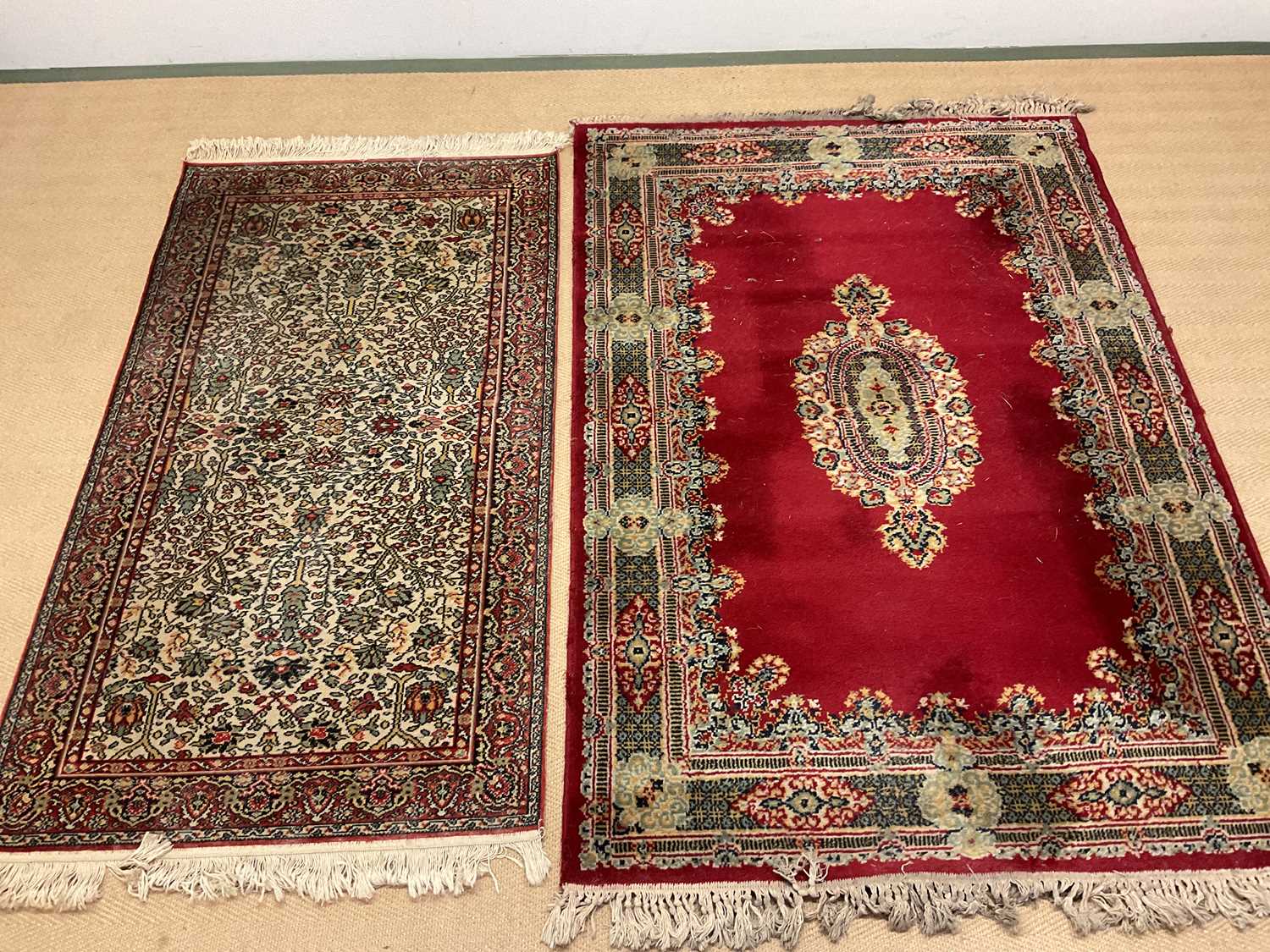 Two vintage Eastern rugs, one a dark red rug with central medallion and decorative border, 122 x
