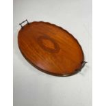 An Edwardian satinwood twin handled tray with gallery, brass handles and central conch shell detail,