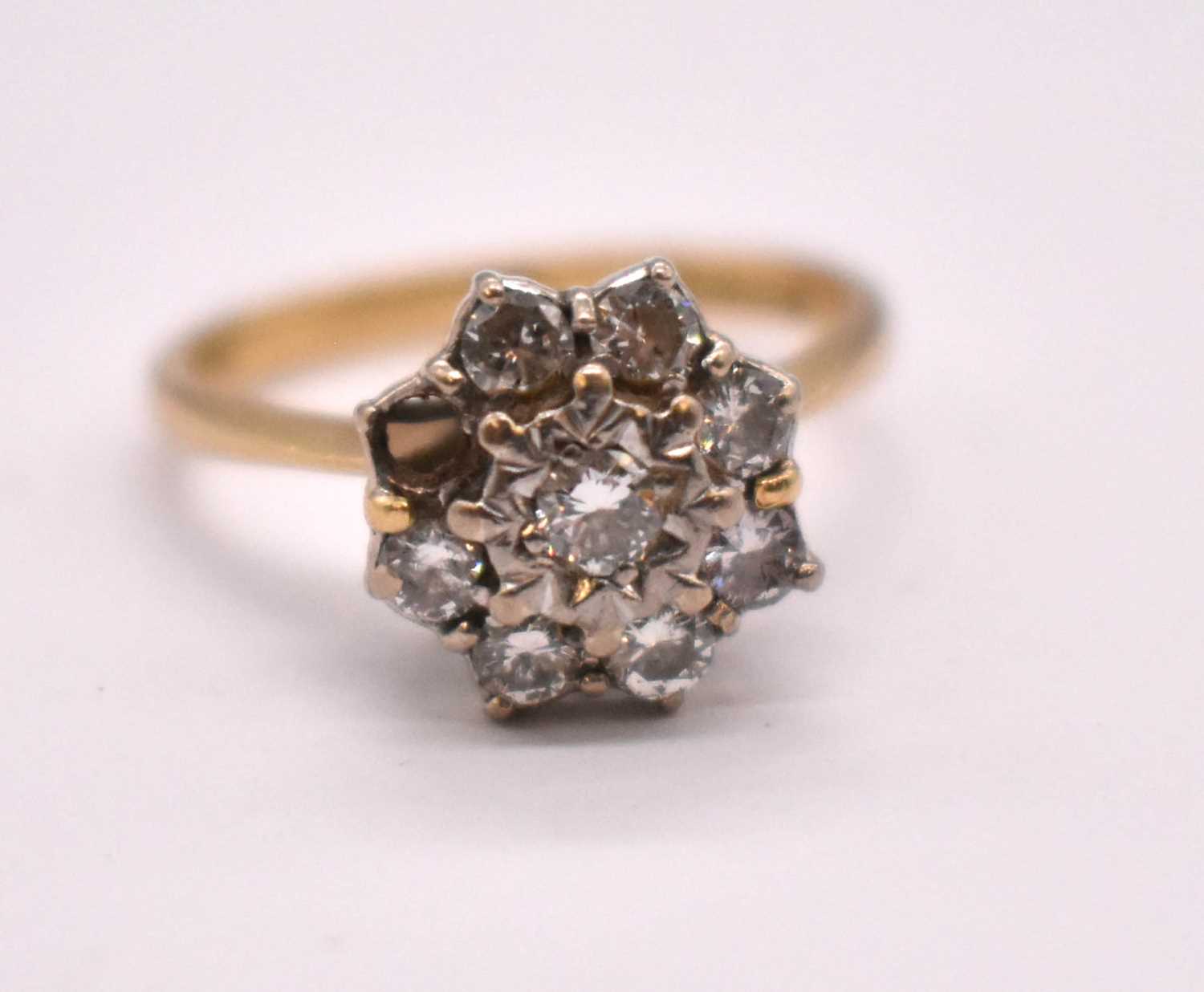 An 18ct yellow gold diamond floral cluster ring, set with eight round brilliant cut stones, each