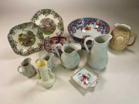 A collection of ceramics including a Beleek jug, graduated set of Portmeirion jugs and other items
