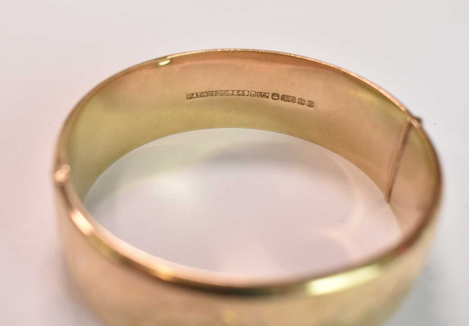 A 9ct yellow gold oval engraved hinged bangle, internal width 57mm, approx 23.2g. - Image 3 of 3