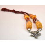 A Sudanese amber white metal and cloth necklace set with several large pieces of eggyolk/