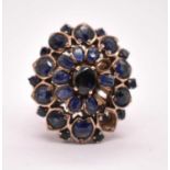 A large yellow metal and sapphire floral cluster ring, size O, approx. 11.16g (three stones