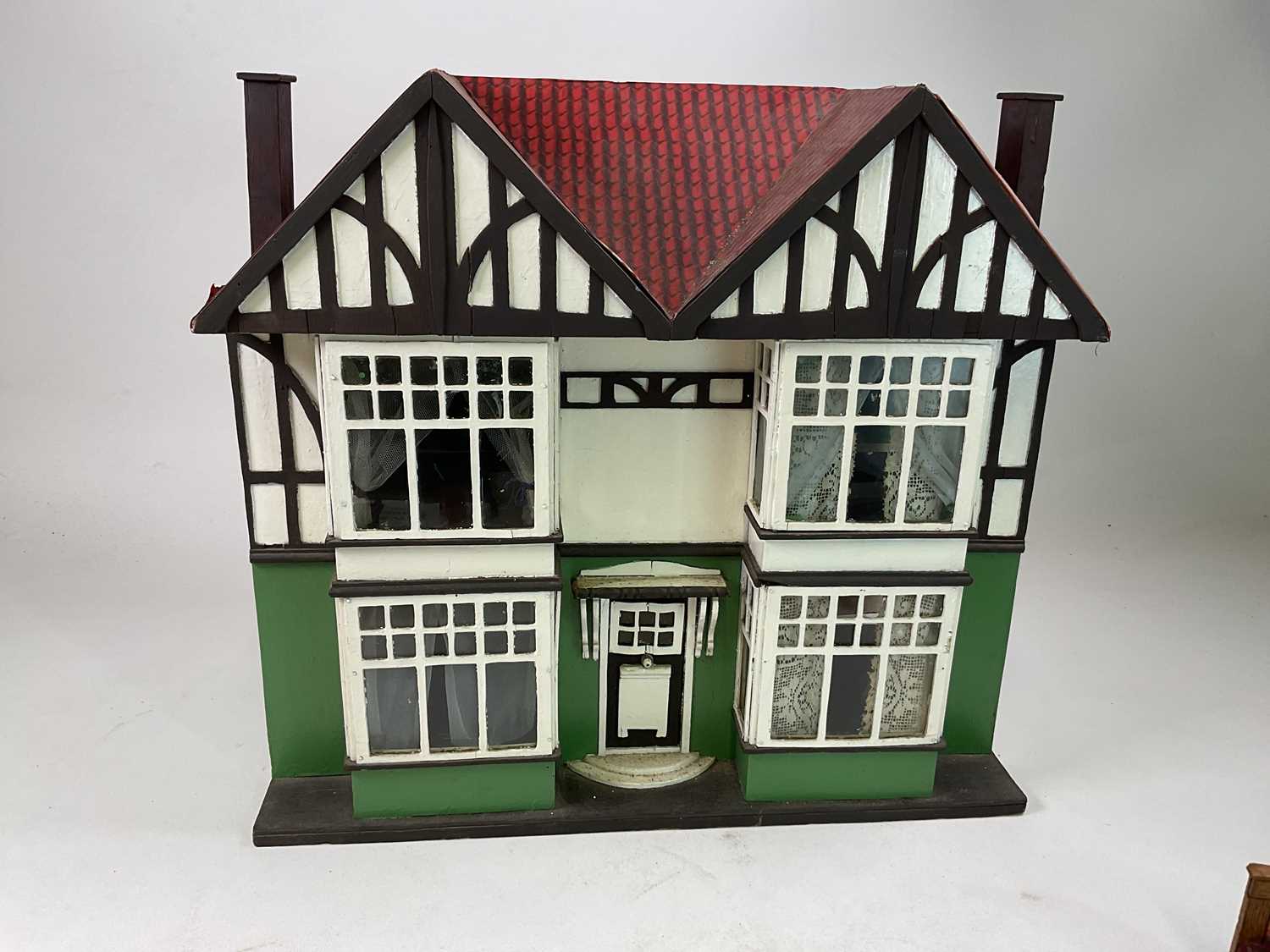 A circa 1920s doll's house in half timber Tudor style with a quantity of furniture and miniature