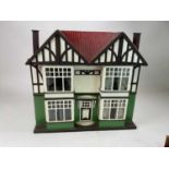 A circa 1920s doll's house in half timber Tudor style with a quantity of furniture and miniature