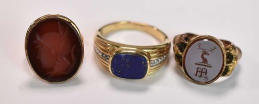 Three yellow metal rings, one set with a carved carnelian, size O, 4.9g approx one with central