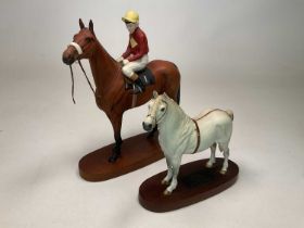 BESWICK; a Connoisseur Model of Red Rum, race horse and jockey raised on wooden plinth, Beswick