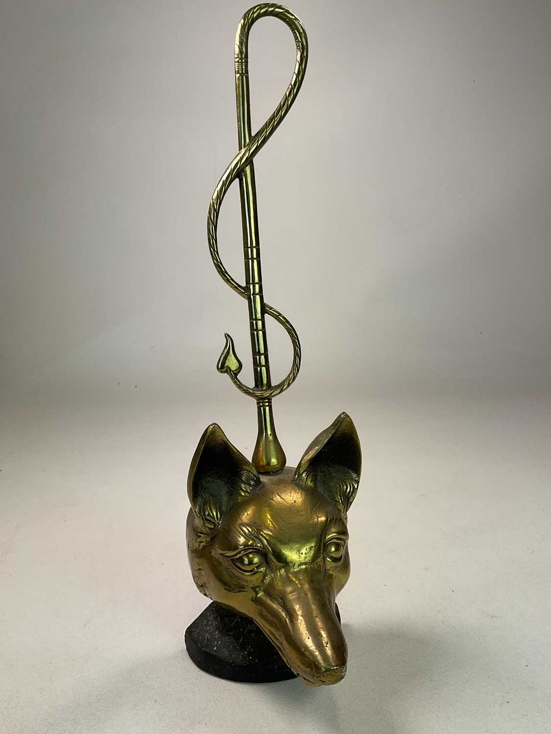 A brass and iron early 20th century doorstop on weighted base modelled as a fox head and whip with