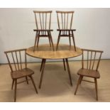 ERCOL; a beechwood and elm drop-leaf table opening to 126cm x 111cm, with four stick back chairs