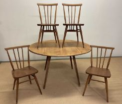 ERCOL; a beechwood and elm drop-leaf table opening to 126cm x 111cm, with four stick back chairs