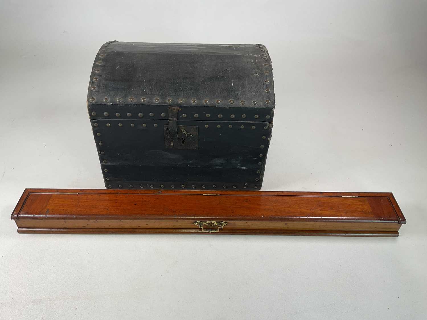 A mahogany desk top tidy, 6 x 87 x 9cm, and small black trunk with studs, 30 x 40 x 32cm.