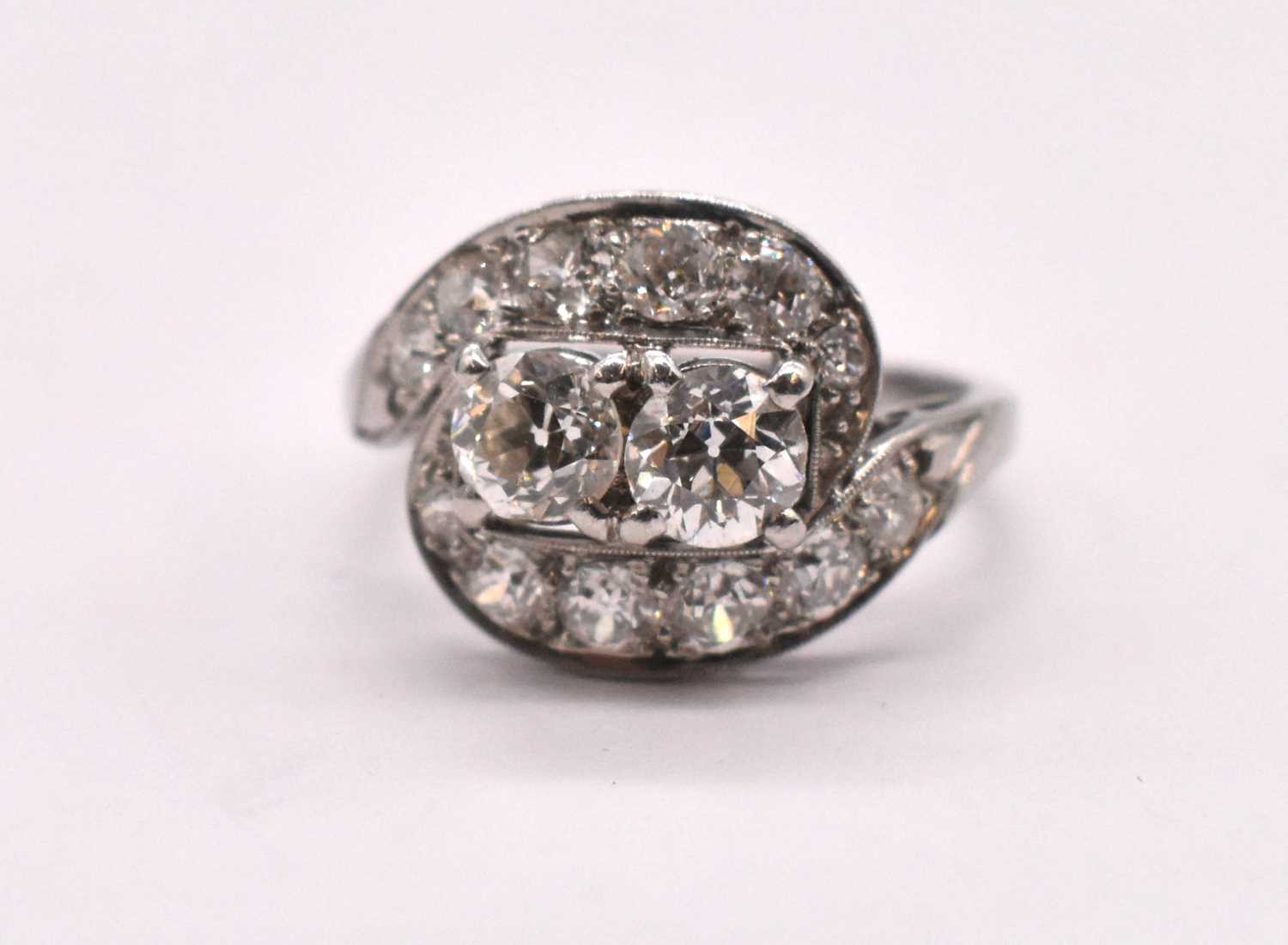 A late 1920s platinum Art Deco diamond set ring with twin raised four claw set round brilliant cut
