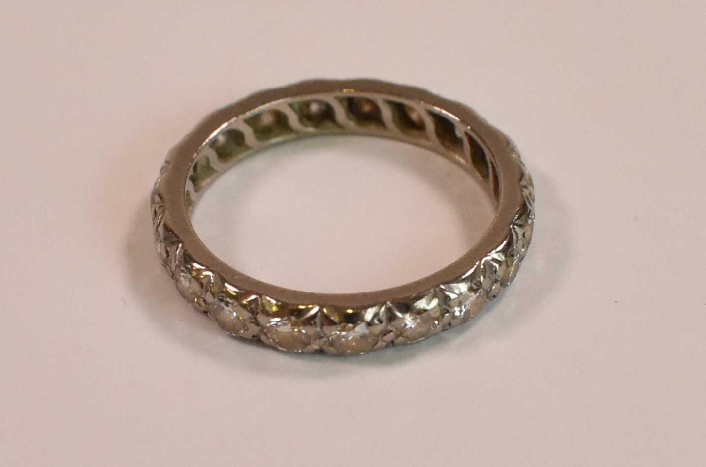 A white metal and diamond set full eternity ring, each round brilliant cut stone weighing approx 0.