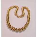 A yellow metal chain formed of compressed spheres sliding on a central chain, the clasp stamped 375,