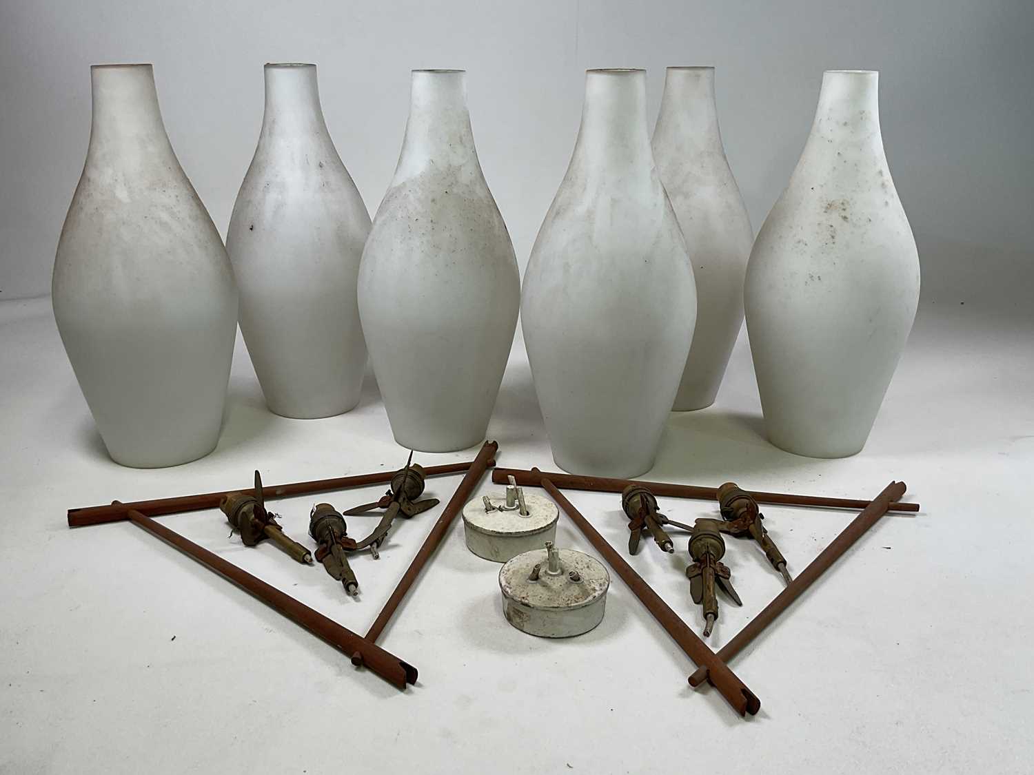 Two sets of mid 20th century Danish pendant lights with a teak triangular frame supporting three