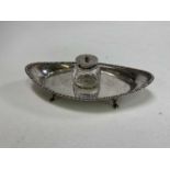 A George V hallmarked silver ink standish of oval boat form with central detachable glass well