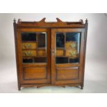 A Victorian oak smoker's cabinet with double glass doors and seven drawers and shelves to