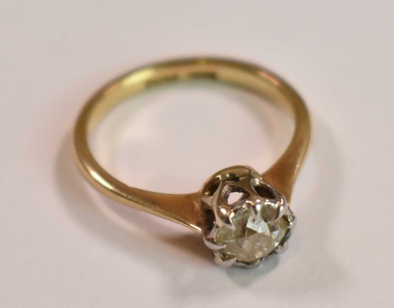 An 18ct yellow gold platinum tipped diamond solitaire ring, the old cushion cut stone weighing