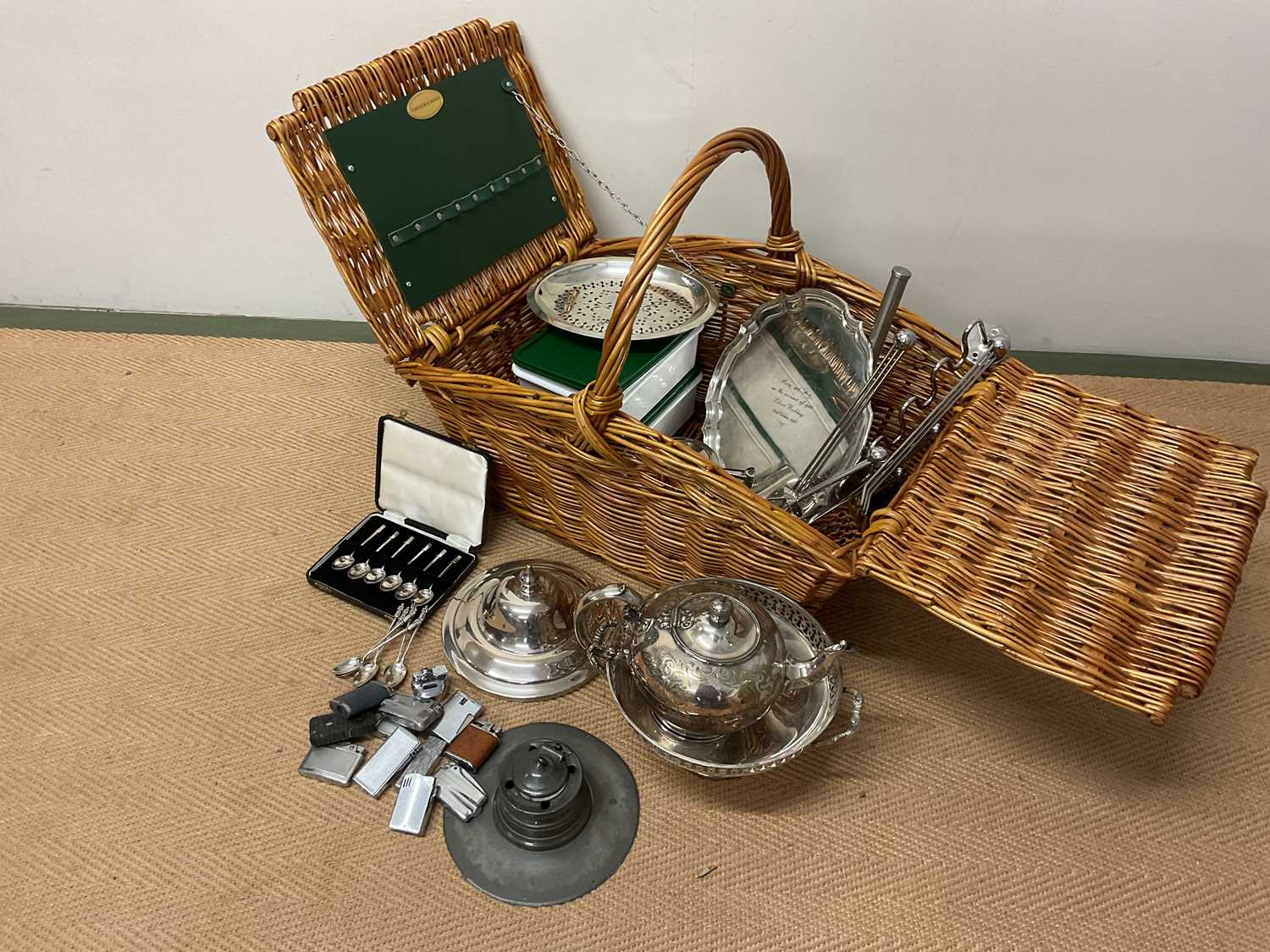 A Fortnum and Mason wicker basket containing silver and plated ware items including a small