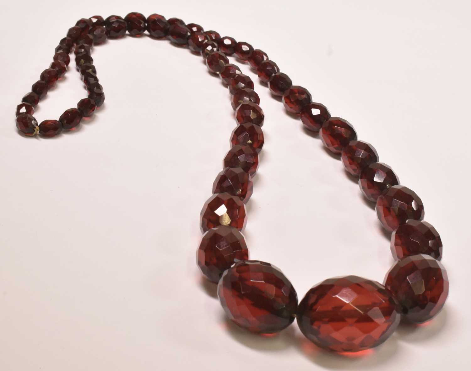A vintage cherry amber graduated facet cut bead necklace, length approx 80cm, largest bead approx - Bild 2 aus 4