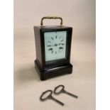 A late 19th century French ebonised and inlaid carriage clock, the swing brass handle showing