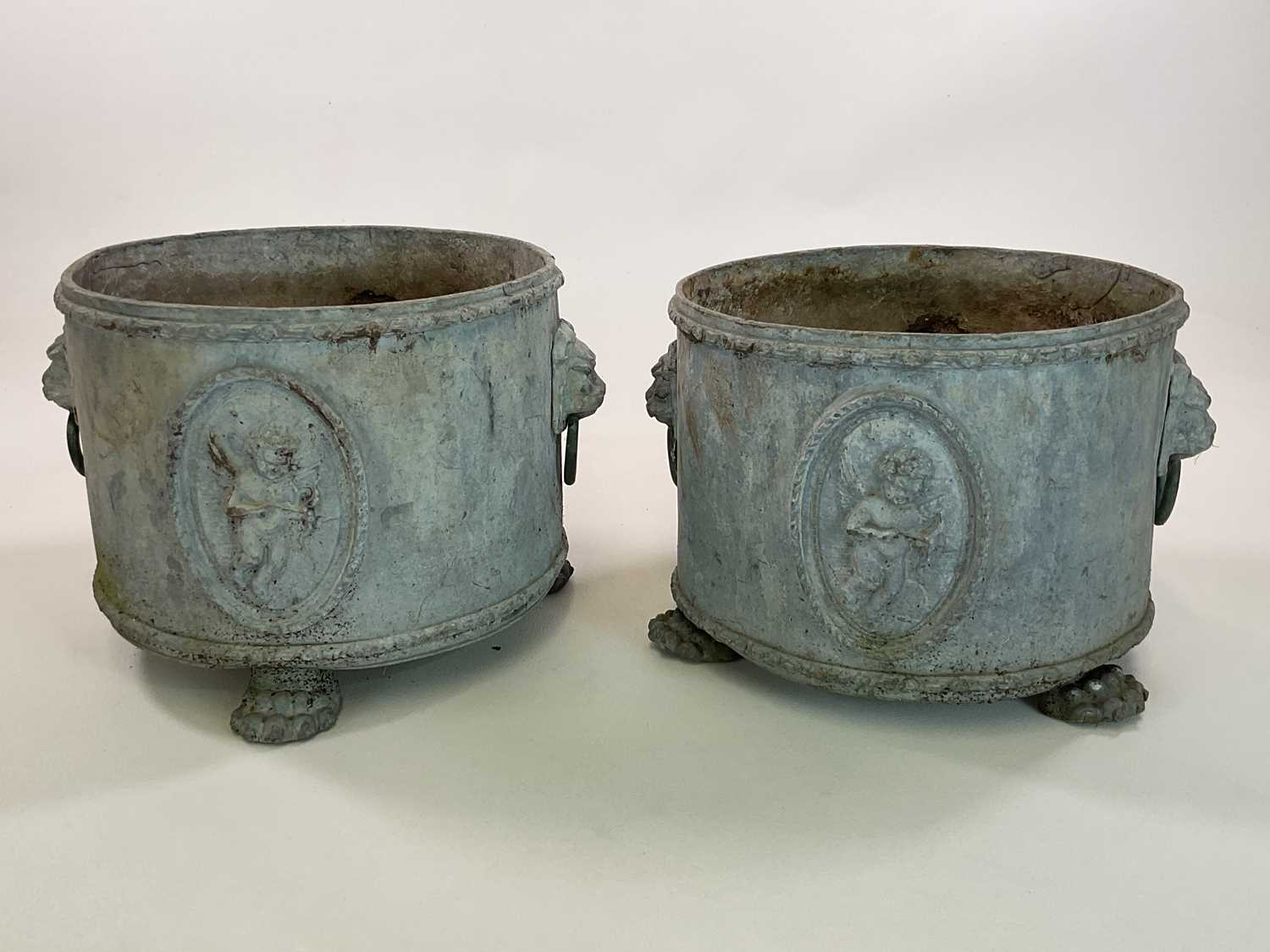 A pair of Georgian style lead planters of circular form with lion mask and ring mounts along with