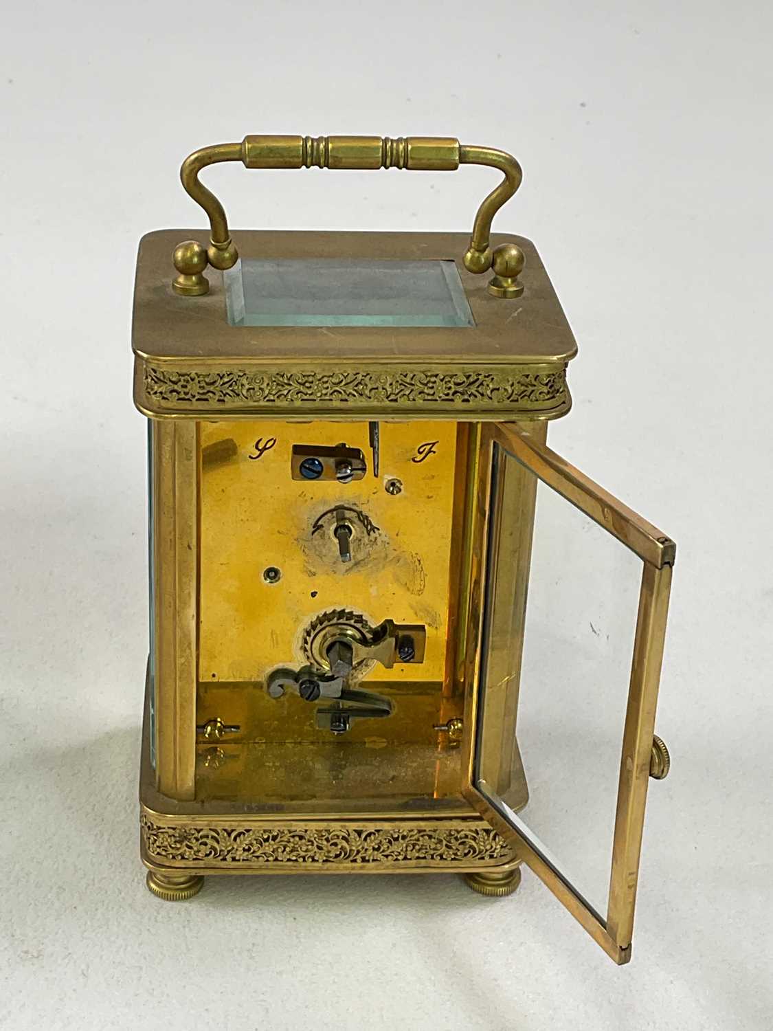 A brass carriage clock with pierced decoration to the case, the enamelled dial set with Arabic - Image 4 of 6