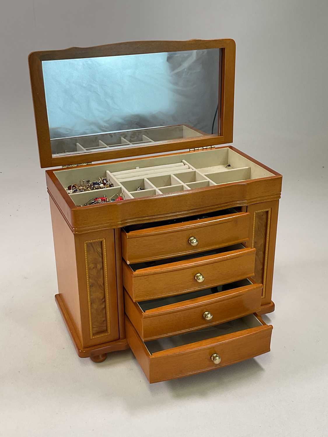 A small collection of costume jewellery contained in a jewellery box, including many yellow metal