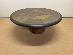 PAUL KINGMA; a circular polished stone table with segmented top, signed within the design, height