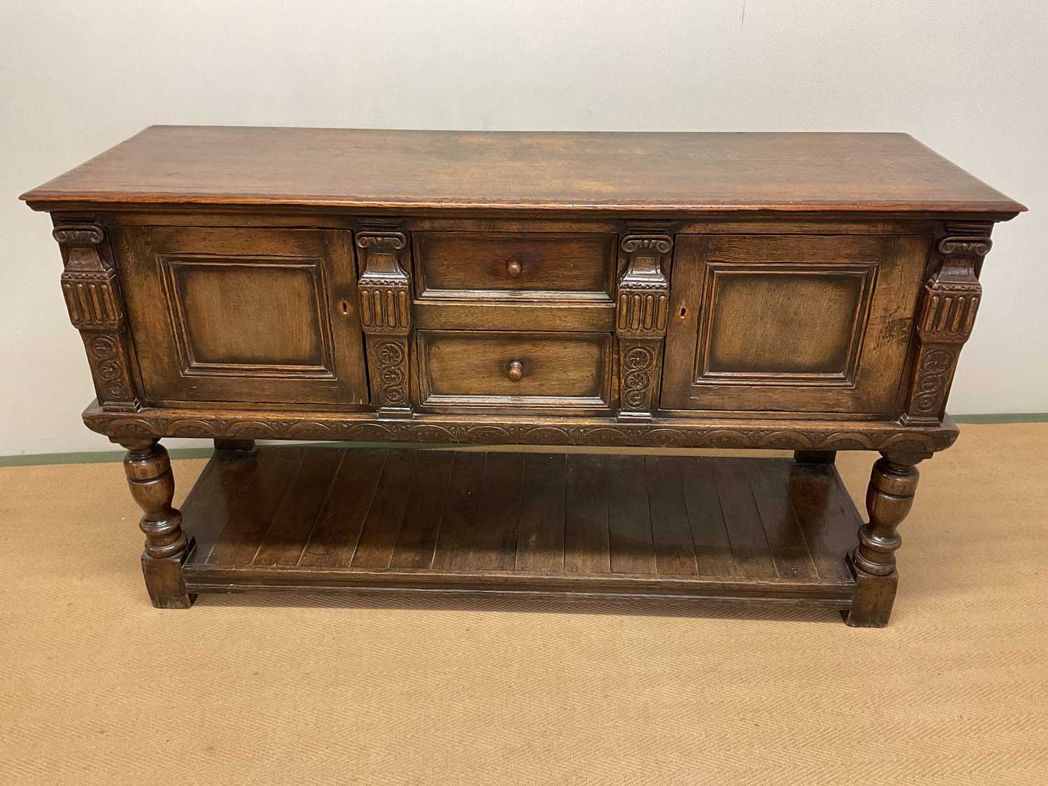 A carved oak sideboard, with two central drawers and two cupboards with lower undertier, height