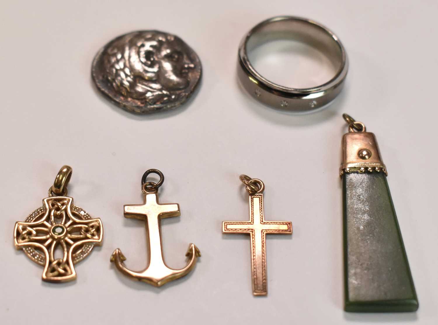 Three 9ct yellow gold pendants; one anchor and two in the form of a cross, combined approx 4.2g,