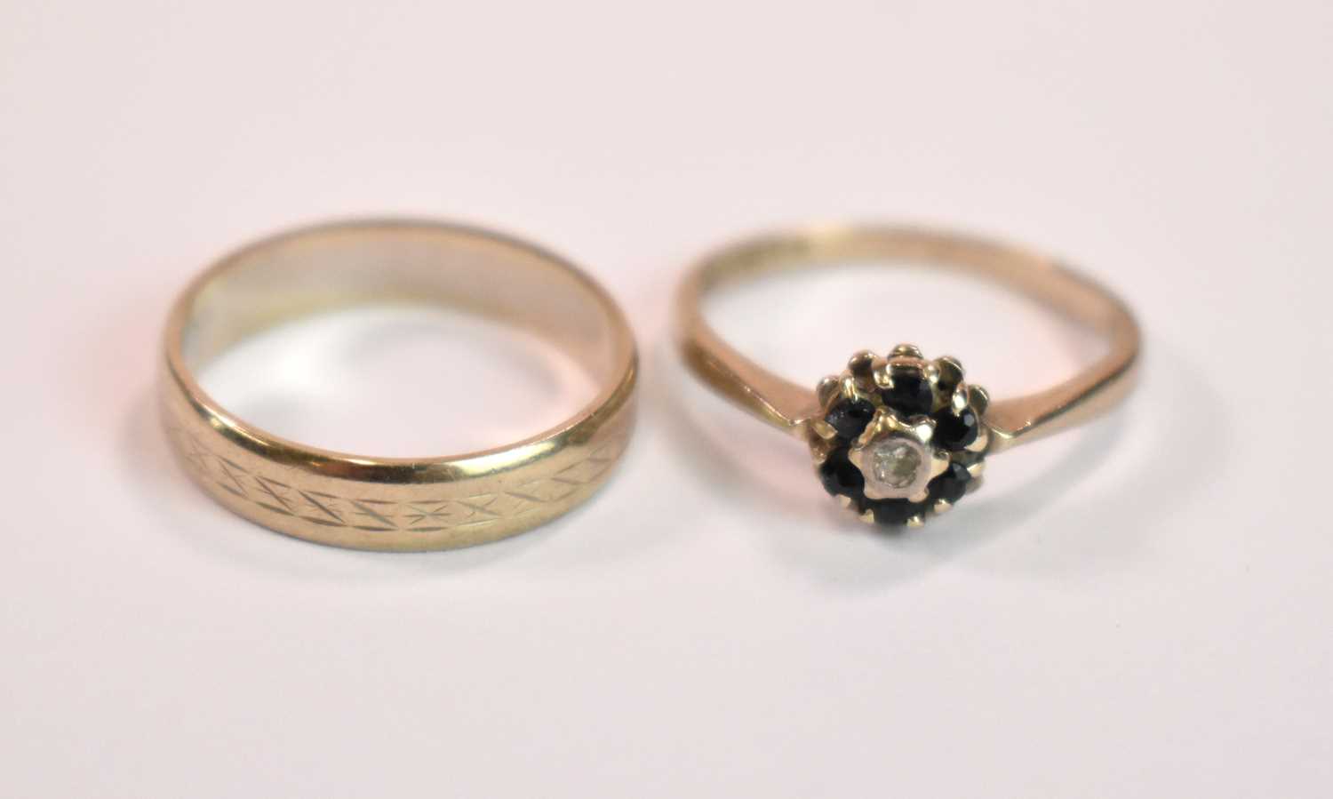 An 18ct yellow gold floral dress ring, size N 1/2, and an 18ct gold wedding band, size O, combined