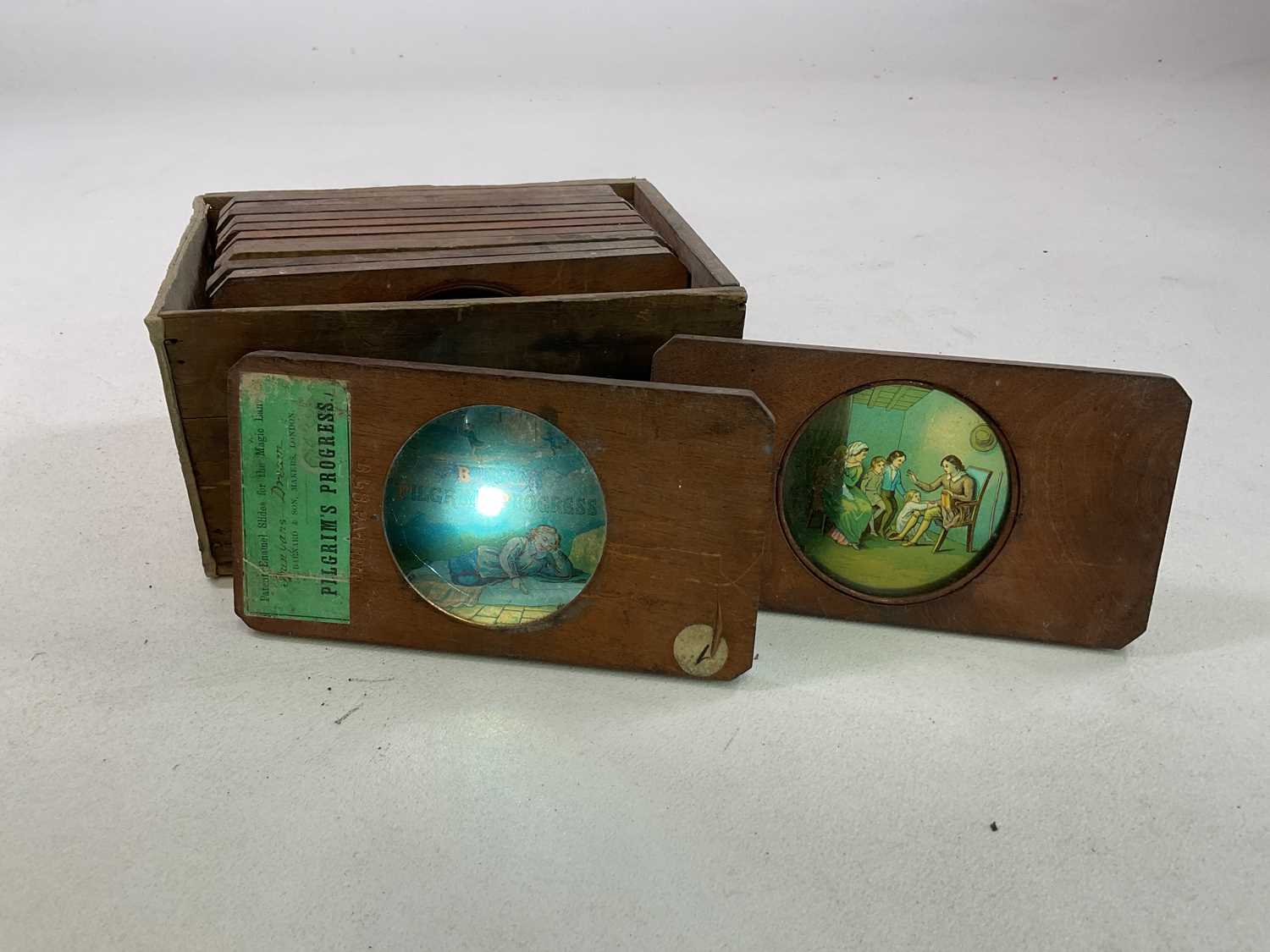 Four magic lanterns in metal cases with a box of slides in wooden frames featuring the Pilgrim's - Image 3 of 6