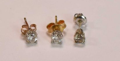 Three single diamond set ear studs, each round brilliant cut four claw set stone weighing approx 0.