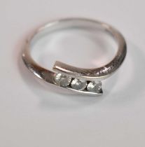 An 18ct white gold and diamond three stone channel set ring, size P, accompanied with the