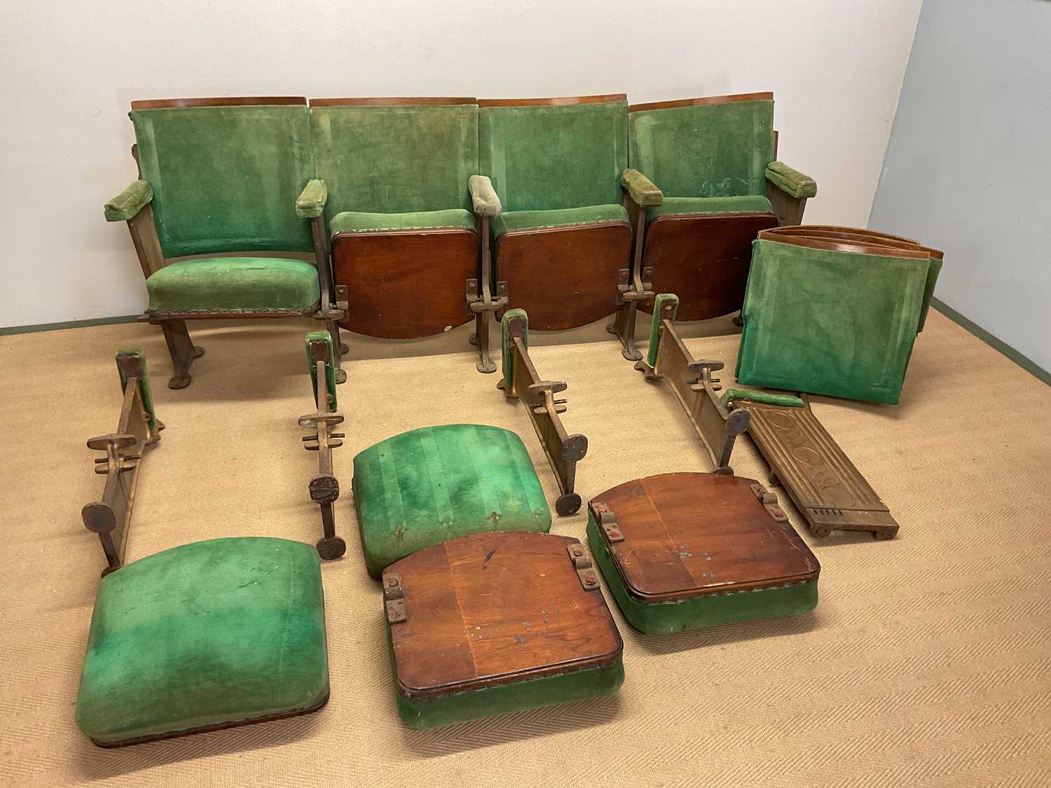 Two rows of four cinema seats with cast iron structures, and one end on each row of four, with green